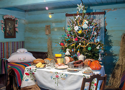 wnętrze mazowieckiej chaty, widok na stół z potrawami i choinkę