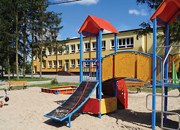 elewacja przedszkola na pierwszym planie zjeżdżalnia na placu zabaw