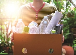 osoba trzyma karton ze śmieciami