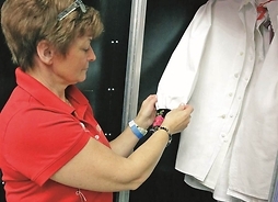 Garderobiana sprawdza oznaczenia wiszących w szafie koszul