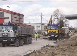samochody ciężarowe transportują surowce potrzebne do budowy drogi