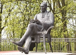 Figura poety siedzącego na krześle zrobiona z brązu