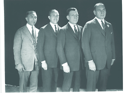 Czterej stojący mężczyźni w garniturach
