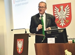 Zdjęcie przedstawia profesora Pawła Swianiewicza przemawiającego do uczestników konferencji