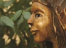 Zbliżenie na rzeźbioną w drewnie twarz kobiecą