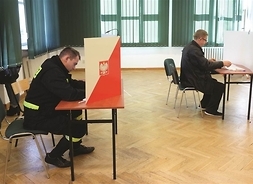 Dwaj mężczyźni podczas głosowania w lokalu wyboryczm