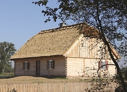 chałupa z dachem naczółkowym, na pierwszym planie drewniany płot