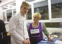 Nauczycielka i uczeń w stroju kucharza przy stole