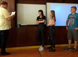 trzech uczniów, dwie dziewczyny i chłopak, odpowiadają na pytania w konkursie wiedzy o transporcie publicznym