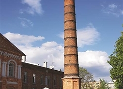 Zdjęcie przedstawia ceglany komin dawnej pralni