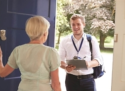 seniorka stoi przy drzwiach, a przed nimi młody mężczyzna