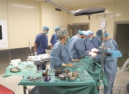 sala operacyjna, lekarze w trakcie operacji pochylają się nad pacjentem