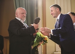 Przewodniczący Sejmiku Województwa Mazowieckiego Ludwik Rakowski wręcza statuetkę Adamowi Myjakowi