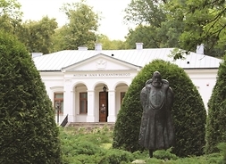 Klasycystyczny dworek z napisem Muzeum Jana Kochanowskiego stoi w otoczeniu drzew pakowych