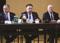 Marszałek Adam Struzik siedzi przy stole w otoczeniu dwóch urzędników
