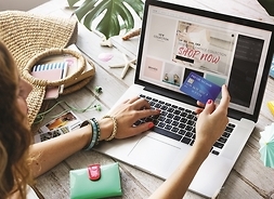 kobieta płaci przez internet za zakupy, widok z góry na laptop i głowę kobiety