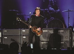 Mężczyzna z gitarą basową stoi na scenie