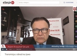 widok na ekran komputera, gdzie widoczny jest mężczyzna w okularach, w tle roll-up Mazowsza serca Polski