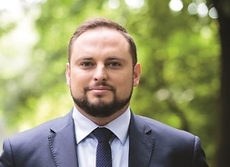 Zdjęcie profilowe radnego Bartosza wiśniakowskiego w stroju oficjalnym, wkonane w plenerze.