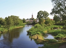 w tle kościół, na pierwszym planie rzeka, widok z perspektywy mostu