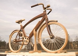 Rower wykonany z drewna, naturalnych rozmiarów. Zdjęcie w plenerze