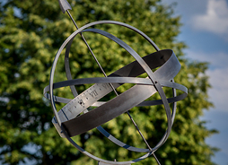 zegar sferyczny, konstrukcja z metalu stoi na cokole z ogrodzie
