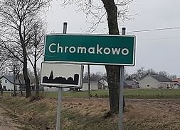 Droga, a przy niej tabliczka z nazwą miejscowości Chromakowo