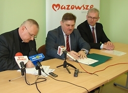 Wicemarszałek Leszek Ruszczyk i ks. Dariusz Skrok podpisują umowę