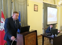 Na mównicy przemawia radny Zielonki Tomasz Wołujewicz. W tle przy stole prezydialny siedzi przewodniczący sejmiku Ludwik Rakowski