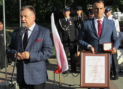 marszałek przemawia do zgromadzonych, dyrektor delegatury UMWM w Płocku Tomasz Kominek prezentuje medal