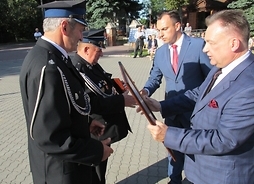 mardzałek Adam Struzik i dyrektor Tomasz Kominek wręczają medal