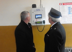Członek zarządu Rafał Rajkowski ze strażakiem OSP w Pawłowicach podczas oglądania systemu selektywnego alarmowania