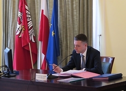Przy stole prezydialnym siedzi przewodniczący Sejmiku Województwa Mazowieckiego Ludwik Rakowski