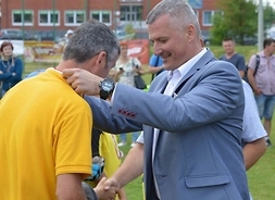 rafał Rajkowski wkłada medaln na szyję jednego z zawodników