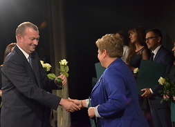 Wicemarszałek Wiesław Raboszuk gratuluje pracowniom jednostki wręczając róże