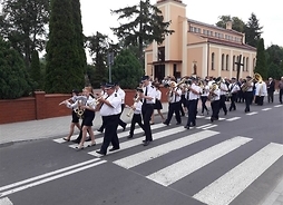 orkiestra idzie ulicą w tle miejscowy kościół