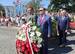 W kolejce z wieńcem kwiatów stoją marszałek i dyrektor delegatury UMWM w Płocku Tomasz Kominek