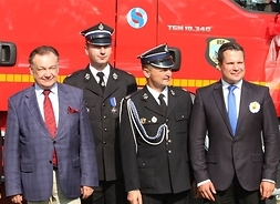 od lewej przed samochodem strażackij stoją marszałek, dwóch strażaków oraz radny województwa Adam Orliński