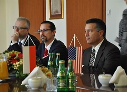 Gubernator i dwaj inni członkowie delegacji przy stole prezydialnym