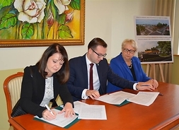 przy stole umowy podpisują prezydent Ciechanowa i wicemarszałek, obok siedzi dyrektor Mazowieckiej Jednostki Wdrażania Programów Unijnych