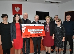 Panie Janina Ewa Orzełowska i Elżbieta Lanc oraz przedstawiciele parafii trzymają symboliczny wielki czek