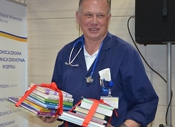 lek. Stanisław Pawełczak z siedleckiego szpitala trzyma w ręku kilkanaście książek dla pacjentów