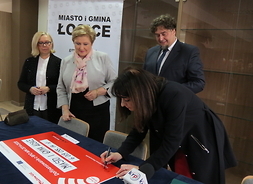 Przedstawiciele zarządu województwa oraz burmistrz Łosic podpisują symboliczny czek
