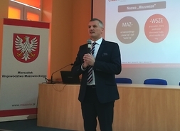 członek zarządu Rafał Rajkowski w pozycji stojącej wygłasza krótkie przemówienie do uczestników spotkania w Radomiu