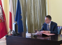 Przewodniczący Sejmiku Województwa Mazowieckiego Ludwik Rakowski siedzi przy stole prezydialnym