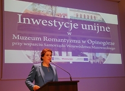 przy mównicy stoi przedstawicielka Muzeum Romantyzmu w Opinogórze