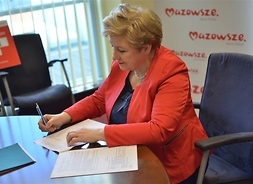 Elżbieta Lanc podpisuje dokumenty
