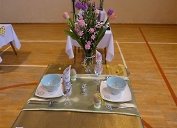 stolik z nakryciami i wazonem kwiatów