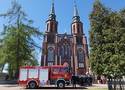 na zdjeciu widać kościół w Liwie, przed wejściem stoją strażacy i samochód gaśniczy
