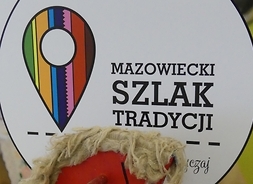 Na zdjęciu widać logo projektu i drewnianego konika na biegunach, który stoi przed plakatem z logiem